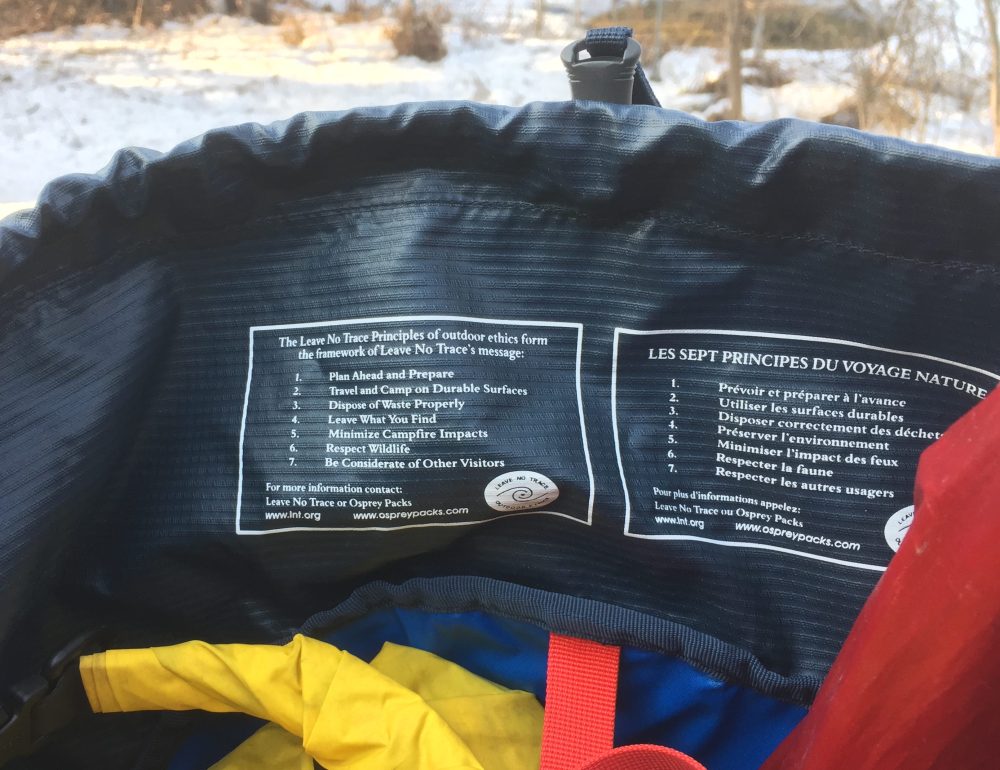A blue backpack with the Leave No Trace Principles written inside.